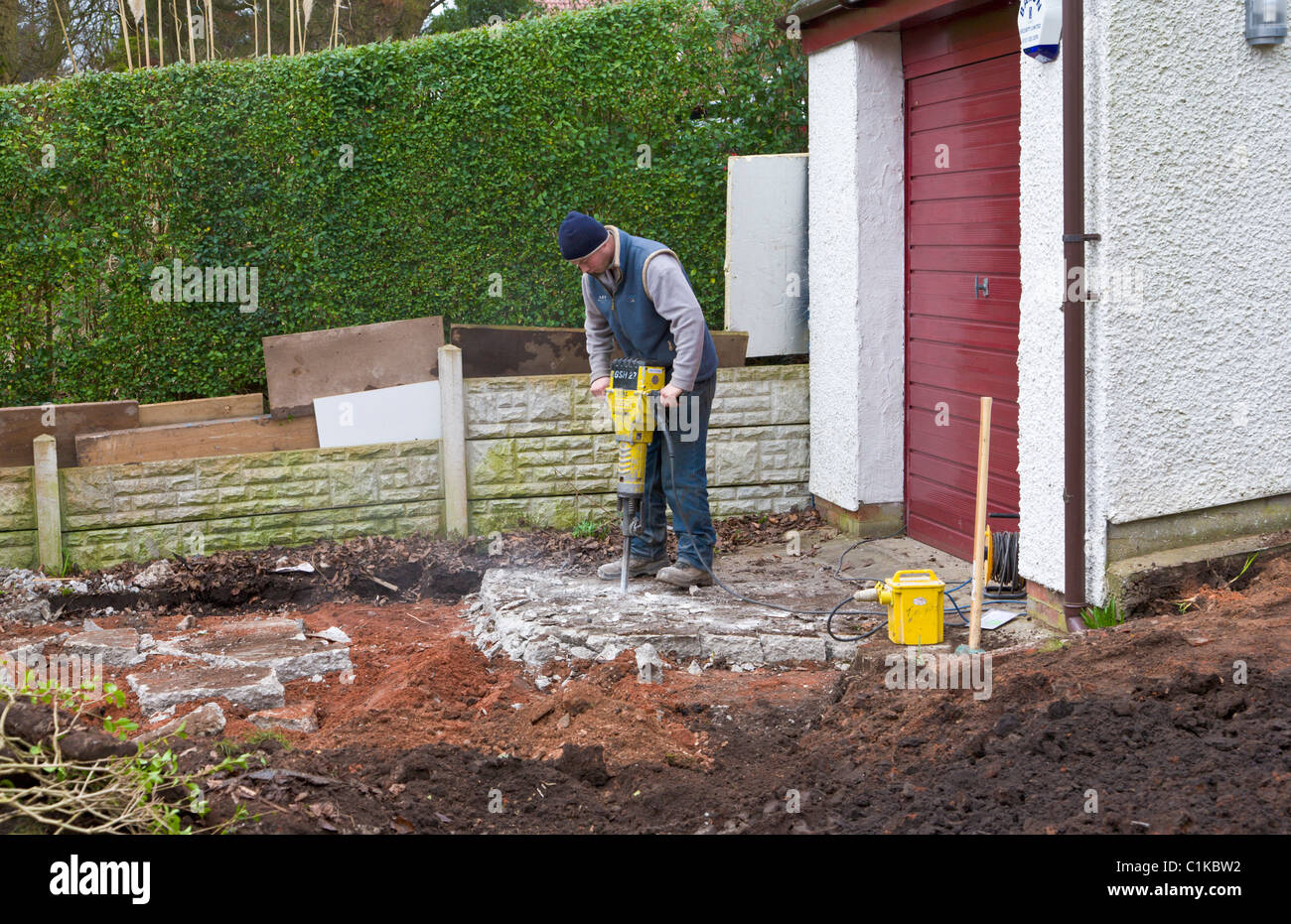 Builder using jackhammer to break up concrete Stock Photo Alamy