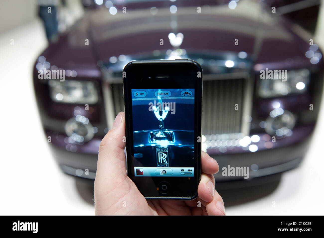 Visitor photographing Rolls-Royce car with phone camera at the Geneva Moto rShow 2011 Switzerland Stock Photo