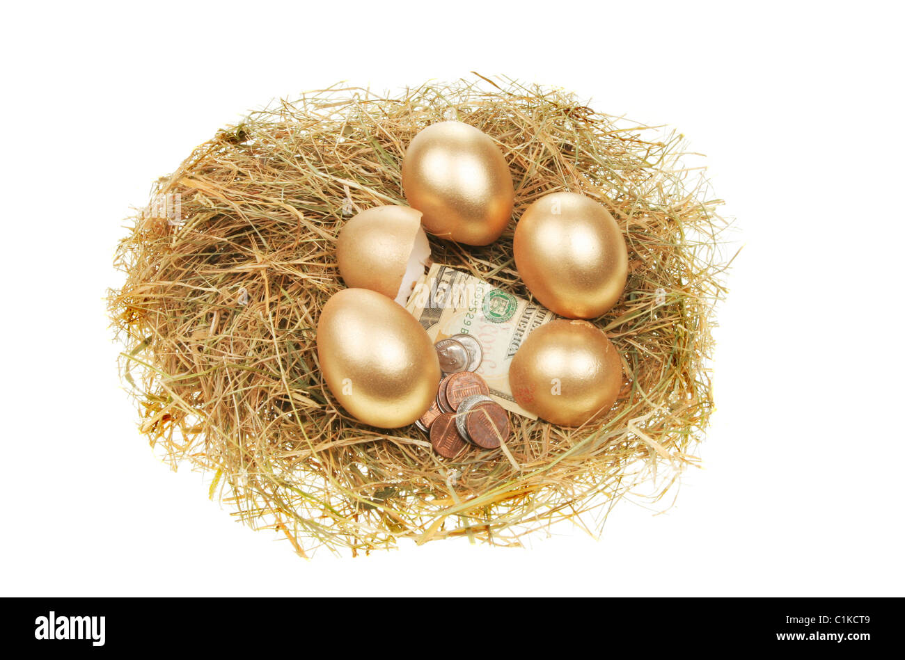 Whole and broken gold eggs with money in a nest of hay Stock Photo