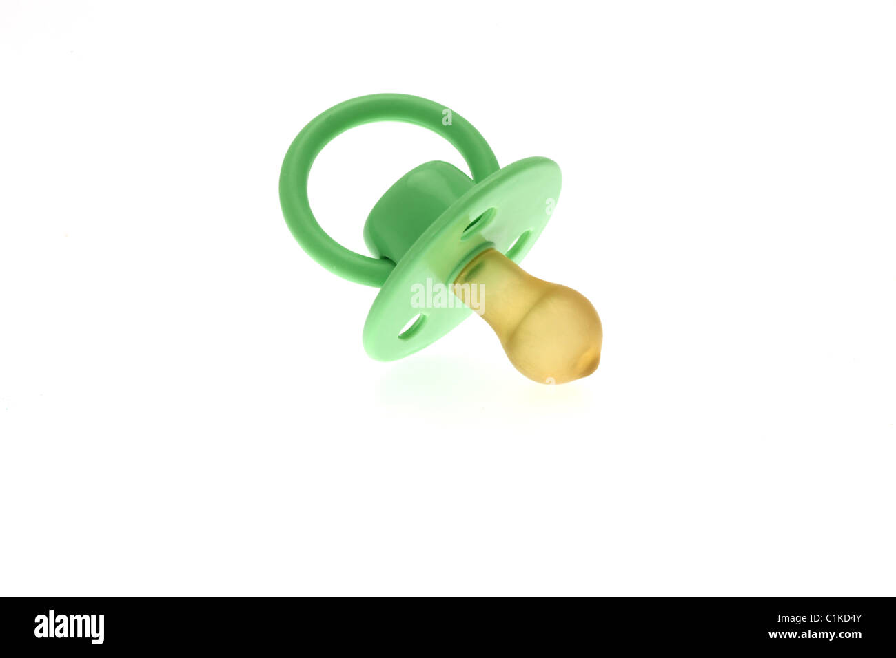High key image of a traditional infants green dummy or pacifier taken against a white background. Stock Photo