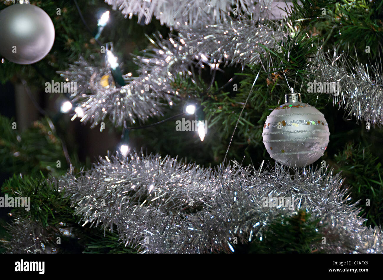 silver baubles and lights on a Christmas tree with tinsel Stock Photo ...