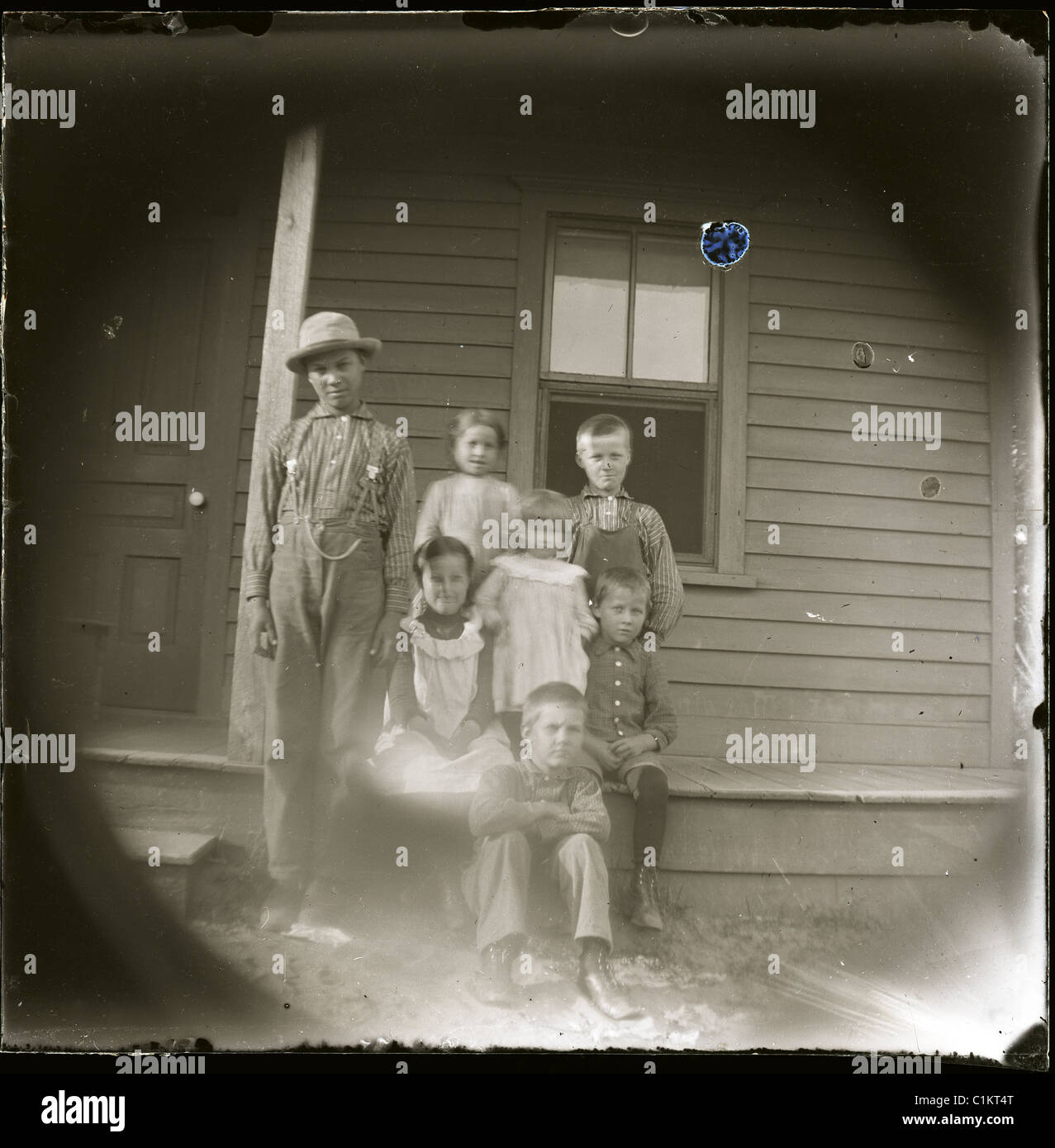 farm children farming Americana black and white glass negative pinhole image porch wood house architecture vintage Stock Photo