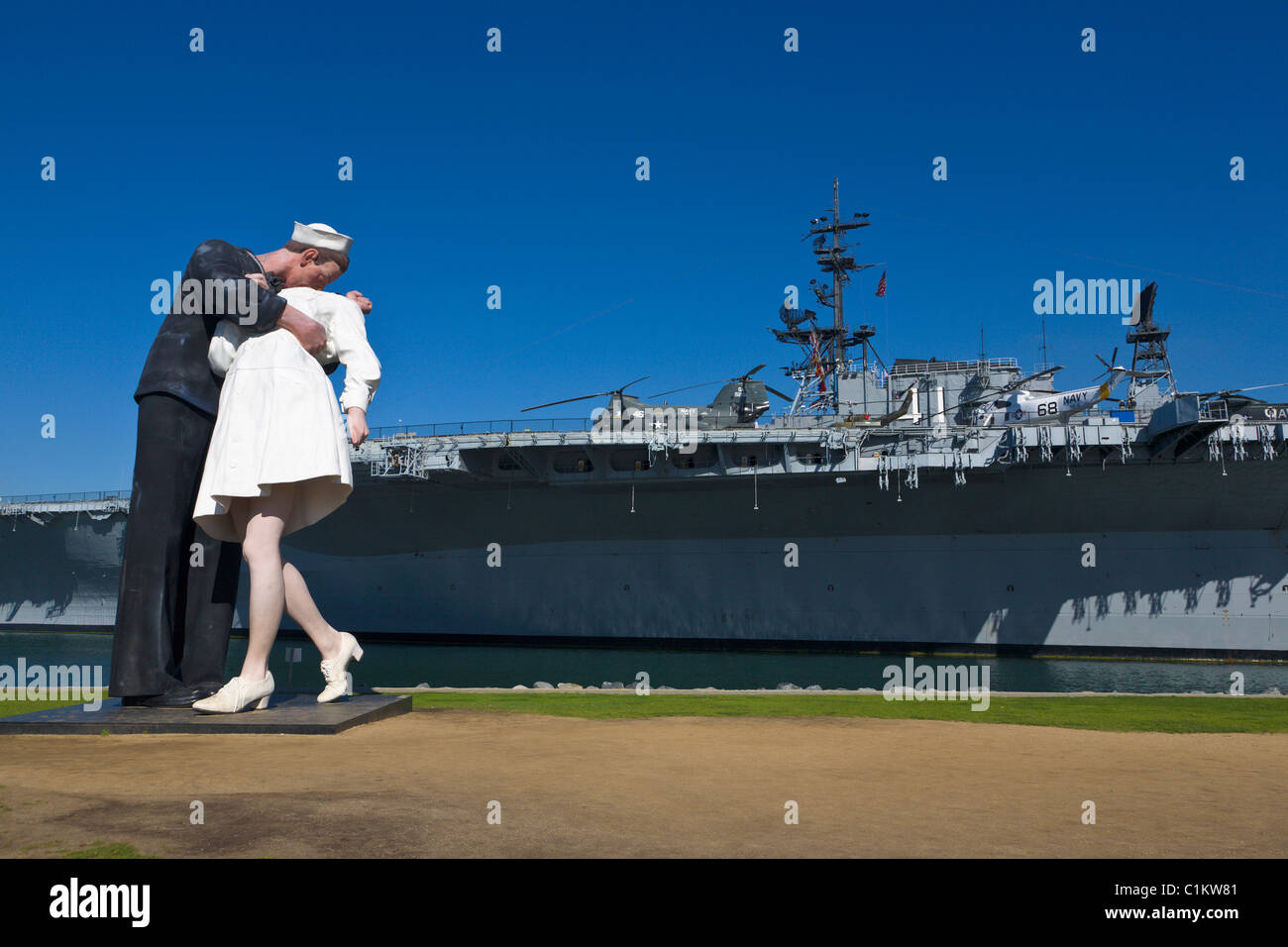 Kissing Couple statue and USS Midway, San Diego, California, USA Stock