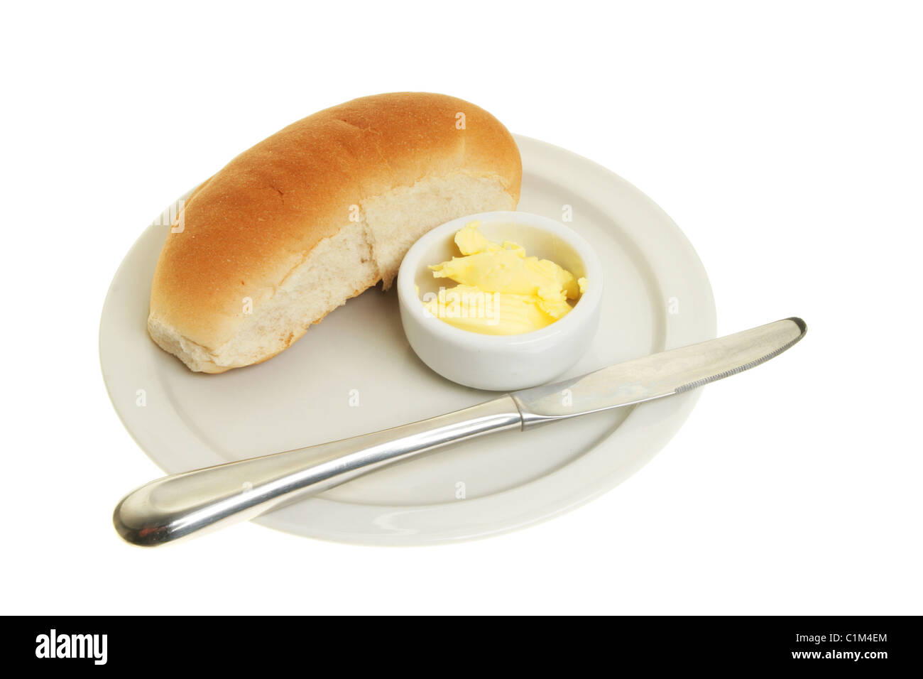 Bread roll, knife and butter on a plate Stock Photo