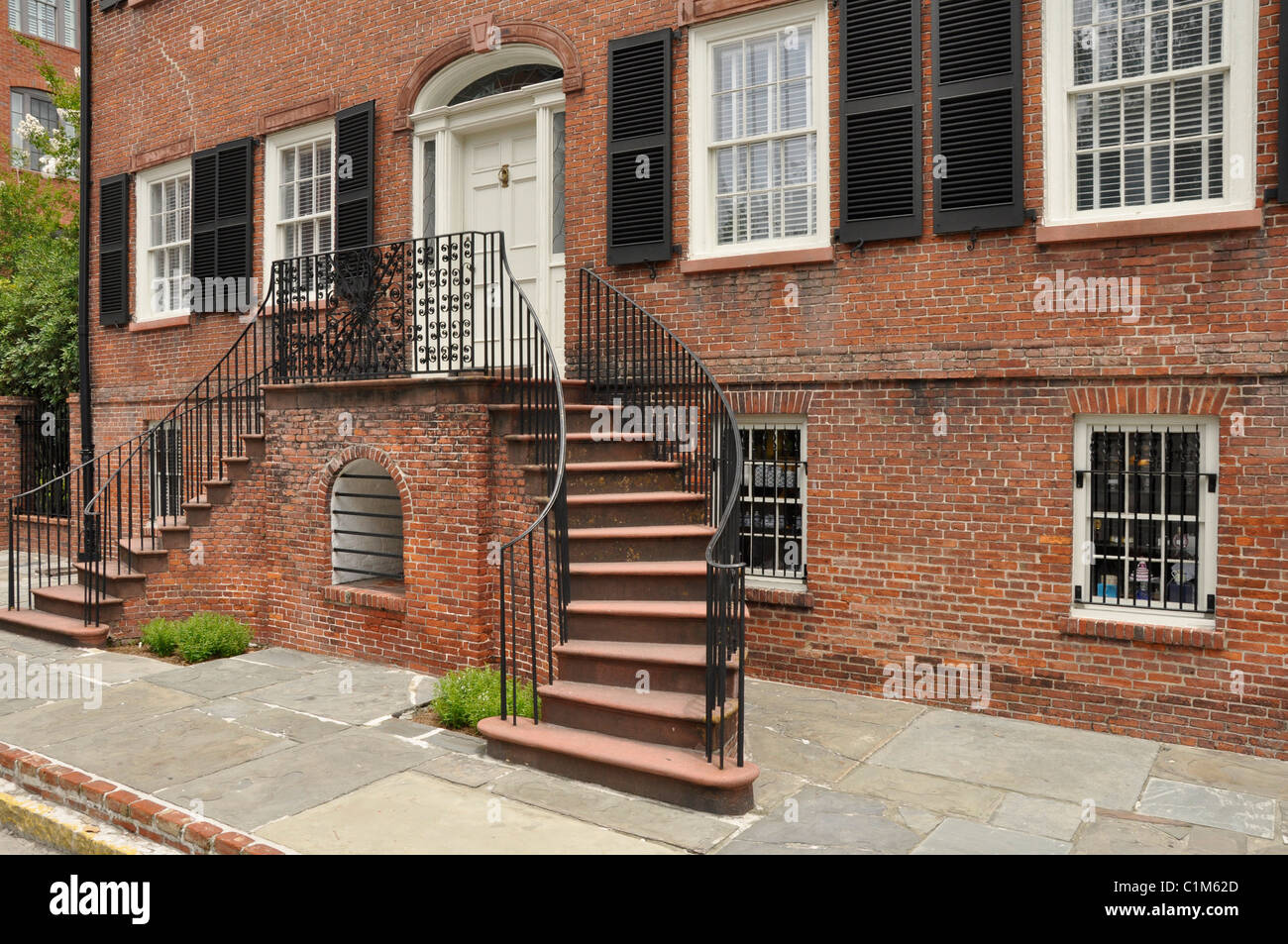 Exterior of an old red brick home with a staircase.  The home is in Savannah, Georgia. Stock Photo