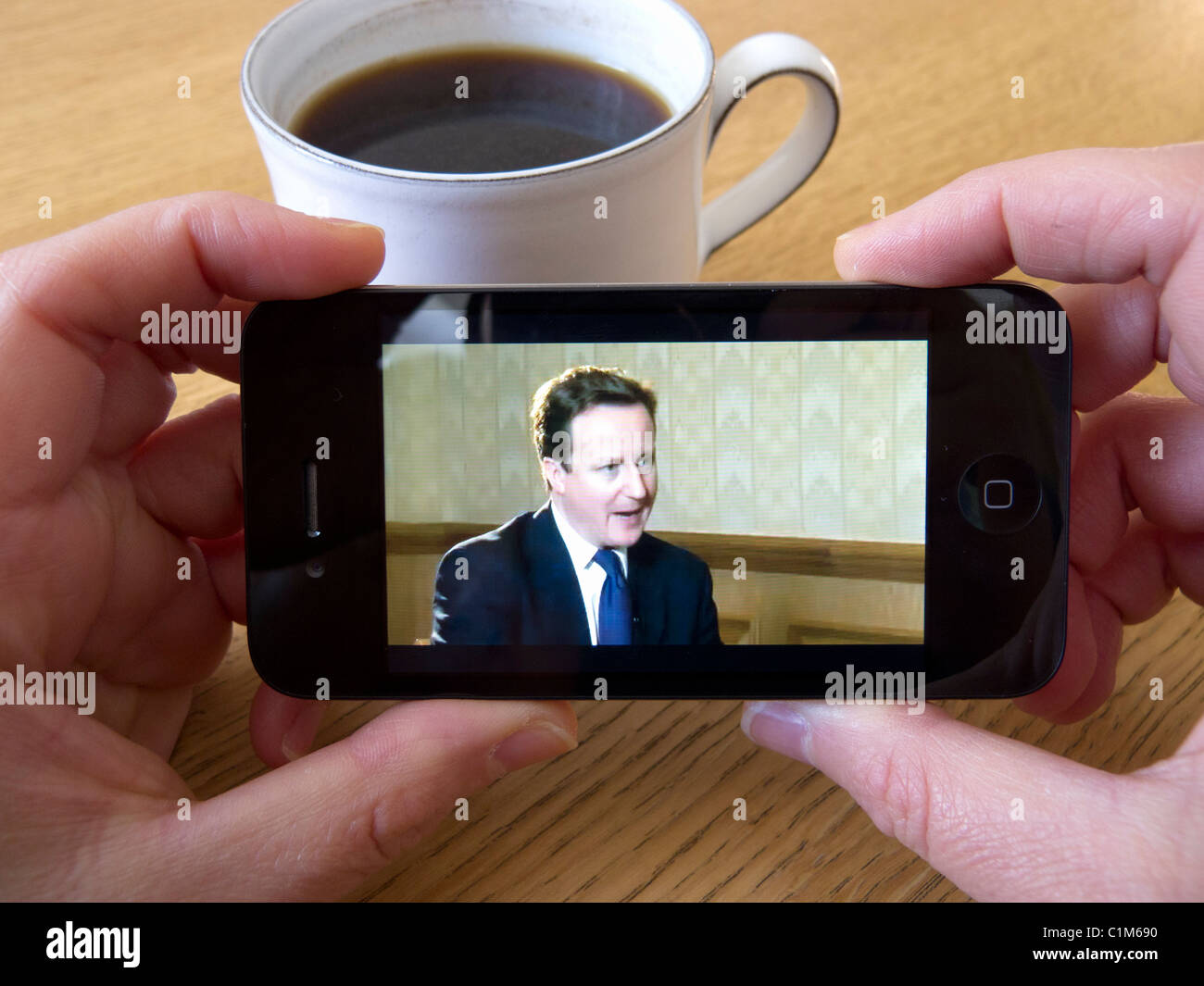 Watching video news of British Prime Minister David Cameron via Youtube on an Apple iphone 4G smart phone Stock Photo