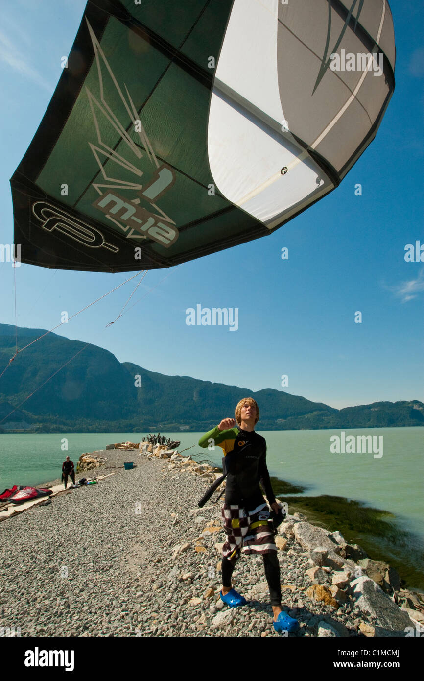 A kiteboarder assists the launch of a kite at 'the Spit', Squamish, BC, Canada. Stock Photo