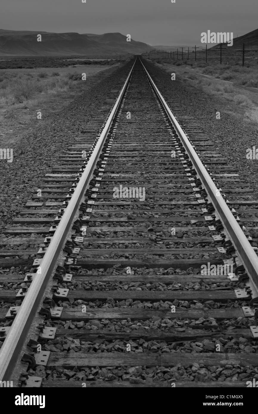 A photograph of a long railroad. The vanishing point leads the eye ...