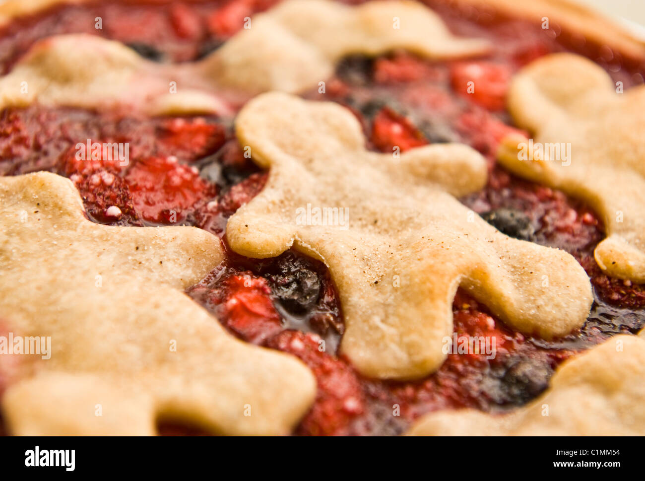 Close-up of a homemade strawberry and blueberry pie with people shaped pastry crust Stock Photo
