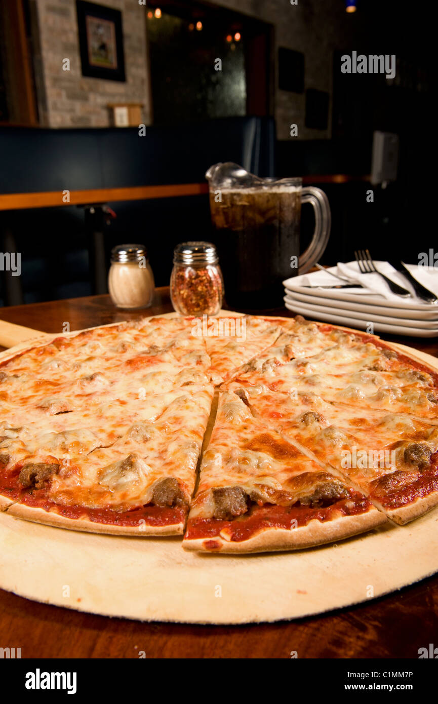 Family size sausage pizza served at a restaurant Stock Photo