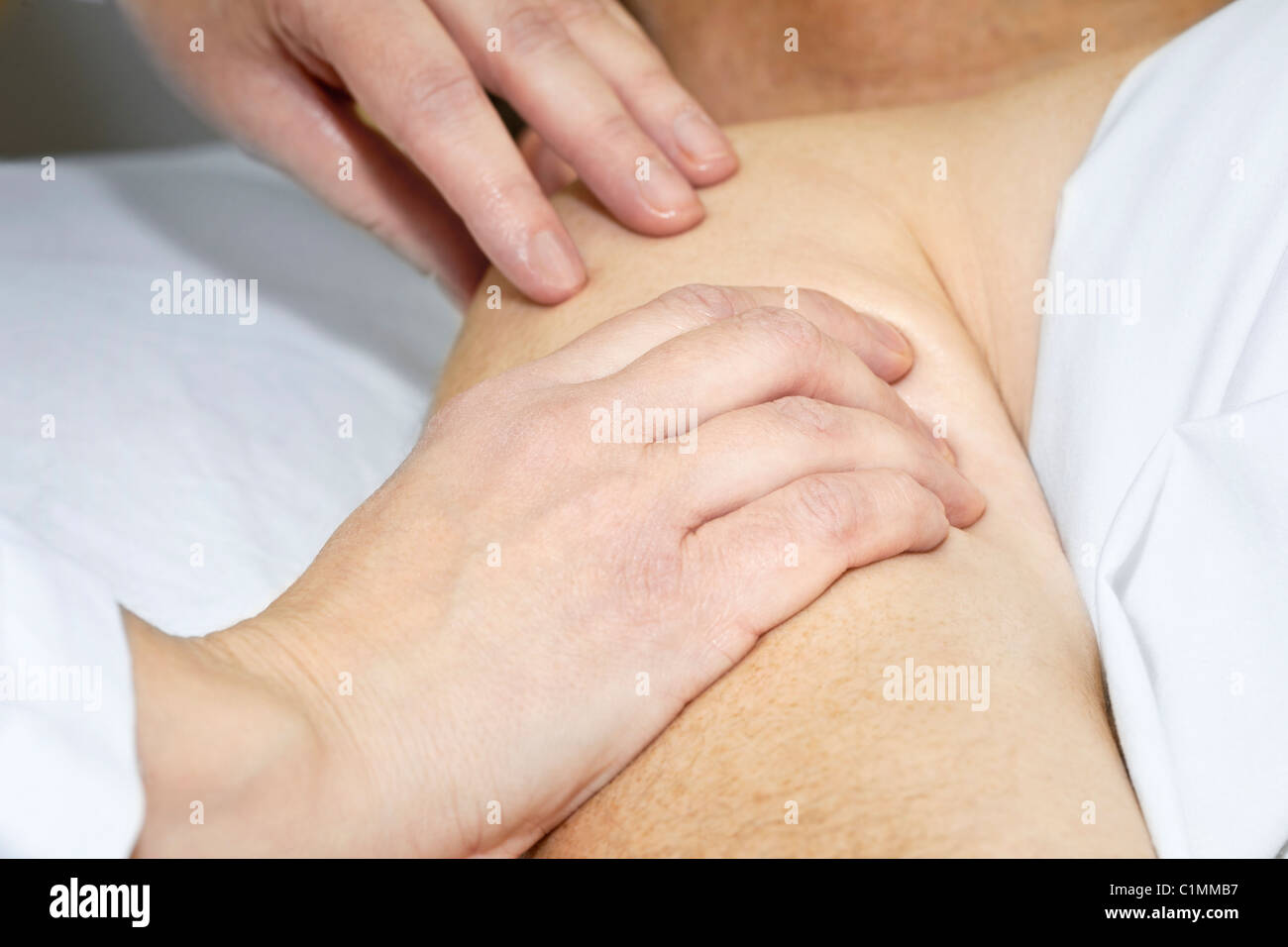 Closeup of female hands massaging arm and shoulder Stock Photo