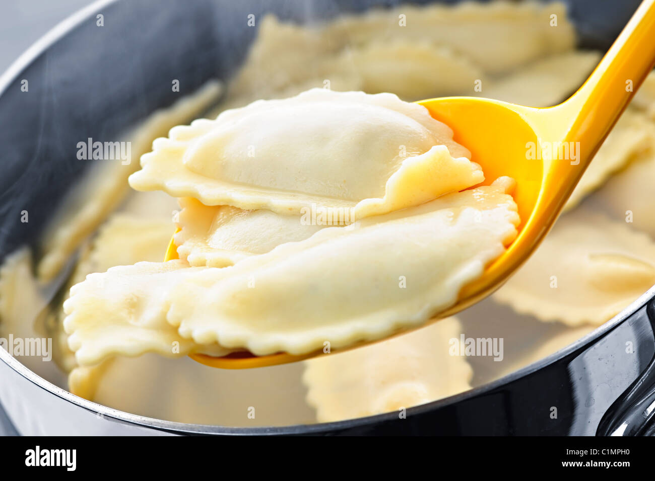 Cooked ravioli lifted from pot on spoon Stock Photo - Alamy