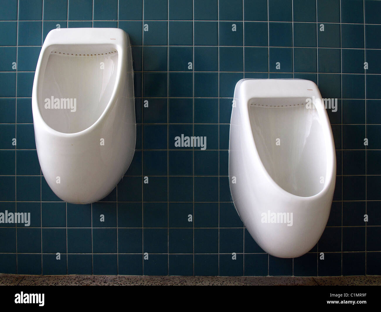 Two urinals set at differing heights for adult and child Stock Photo