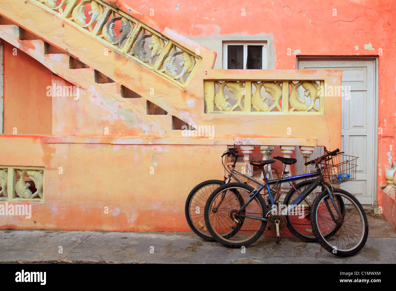 bicycles on grunge tropical Caribbean orange yellow facade Mexico Stock Photo