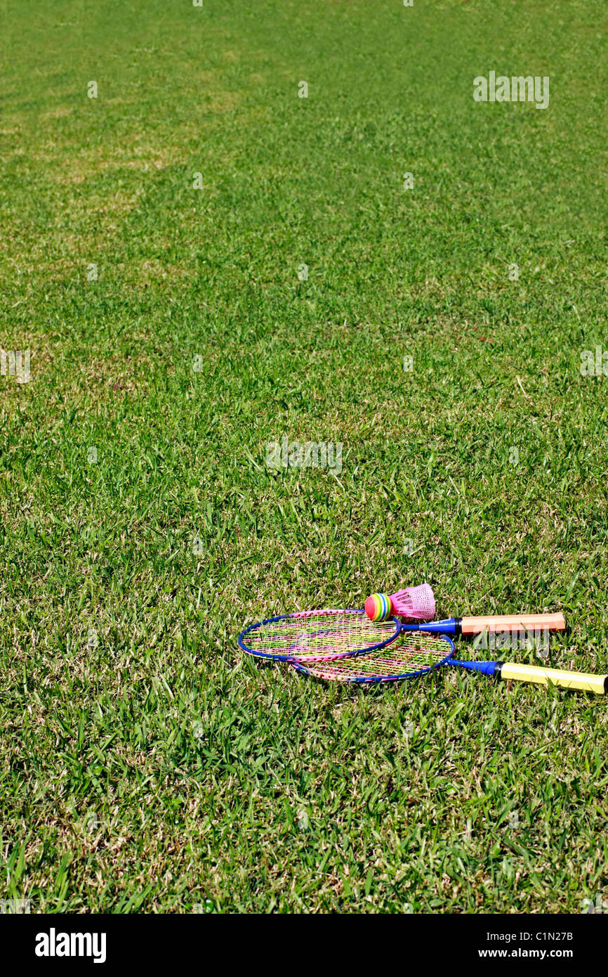Lawn badminton racquets and shuttlecock on a stretch of grass Stock