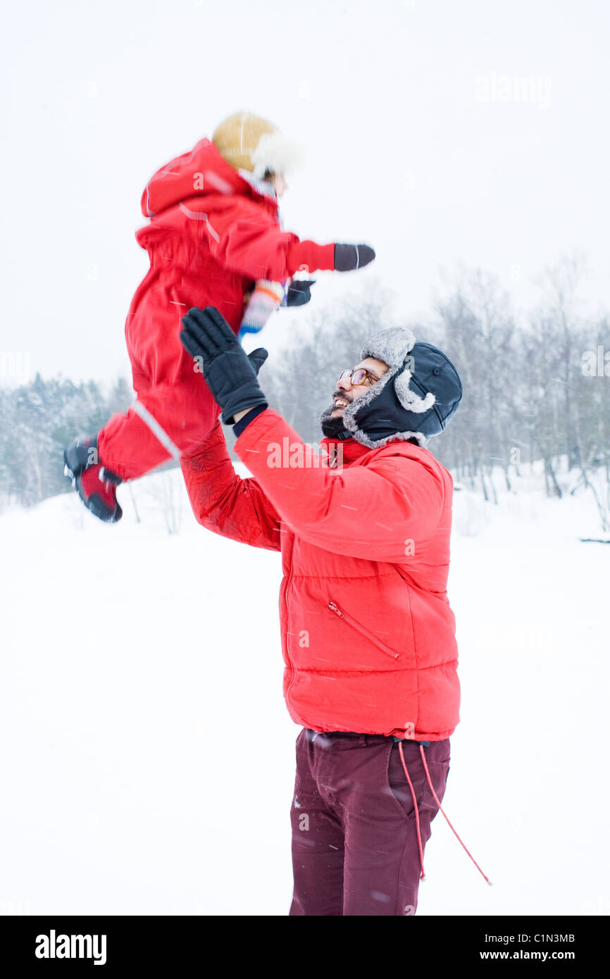 Father and daughter in winter clothing playing outdoors Stock Photo