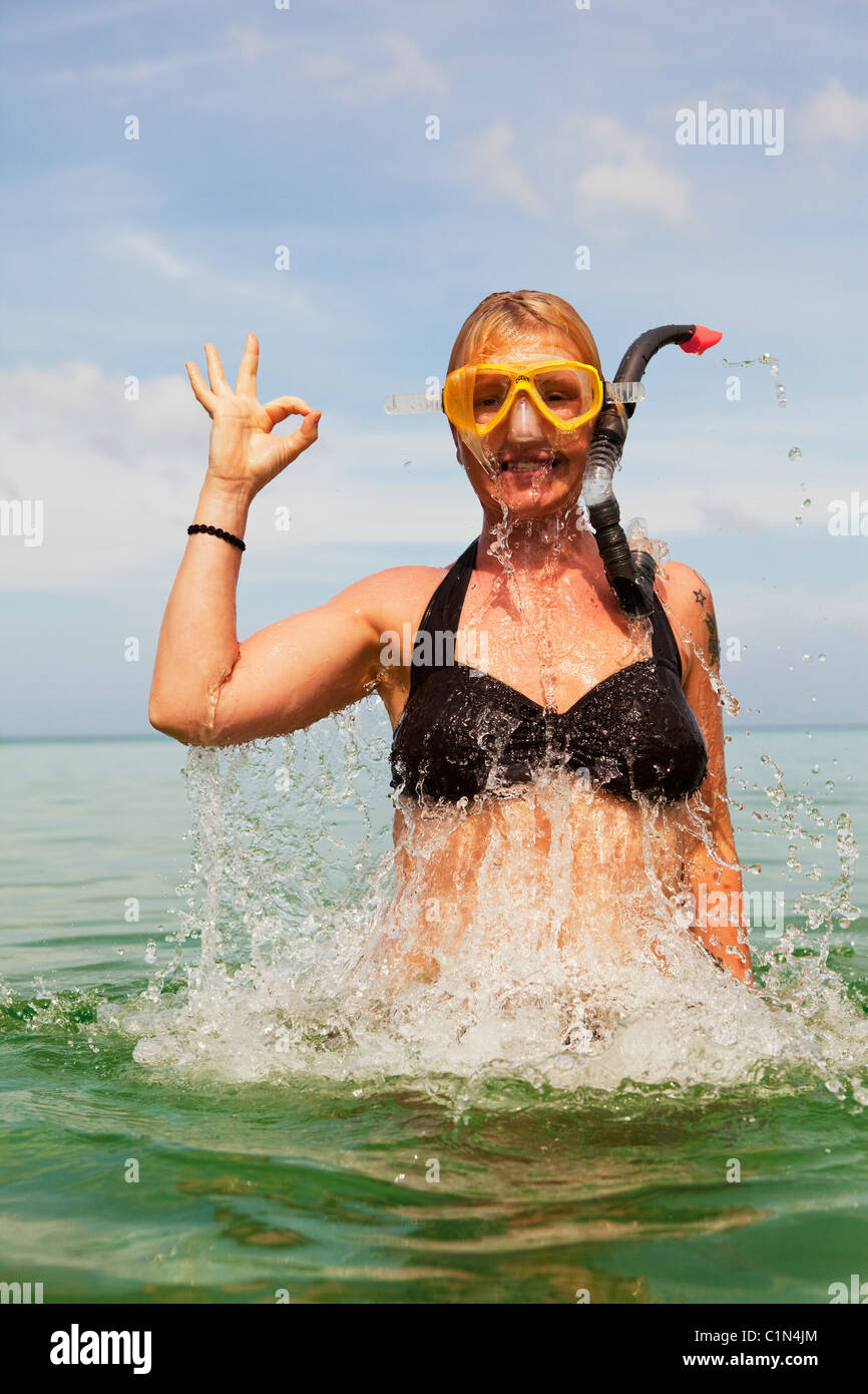 Woman snorkeling in sea showing ok sign with hand Stock Photo