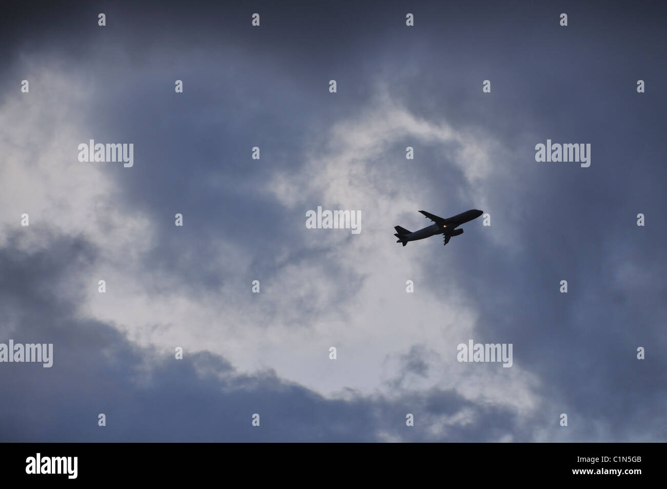 Plane flying at a cloudy sky Stock Photo - Alamy