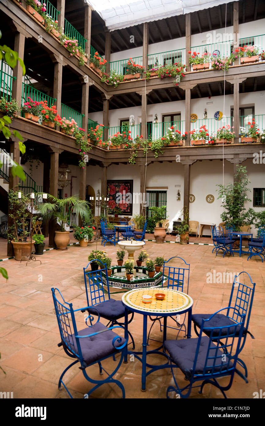 Interior / internal courtyard and table / chairs of tourist hotel / hosteria in the old city / historic area of Seville. Spain. Stock Photo