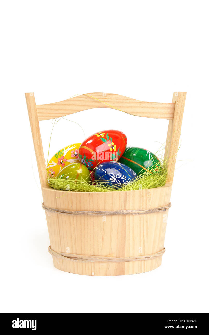 Easter eggs in wooden basket over white background Stock Photo