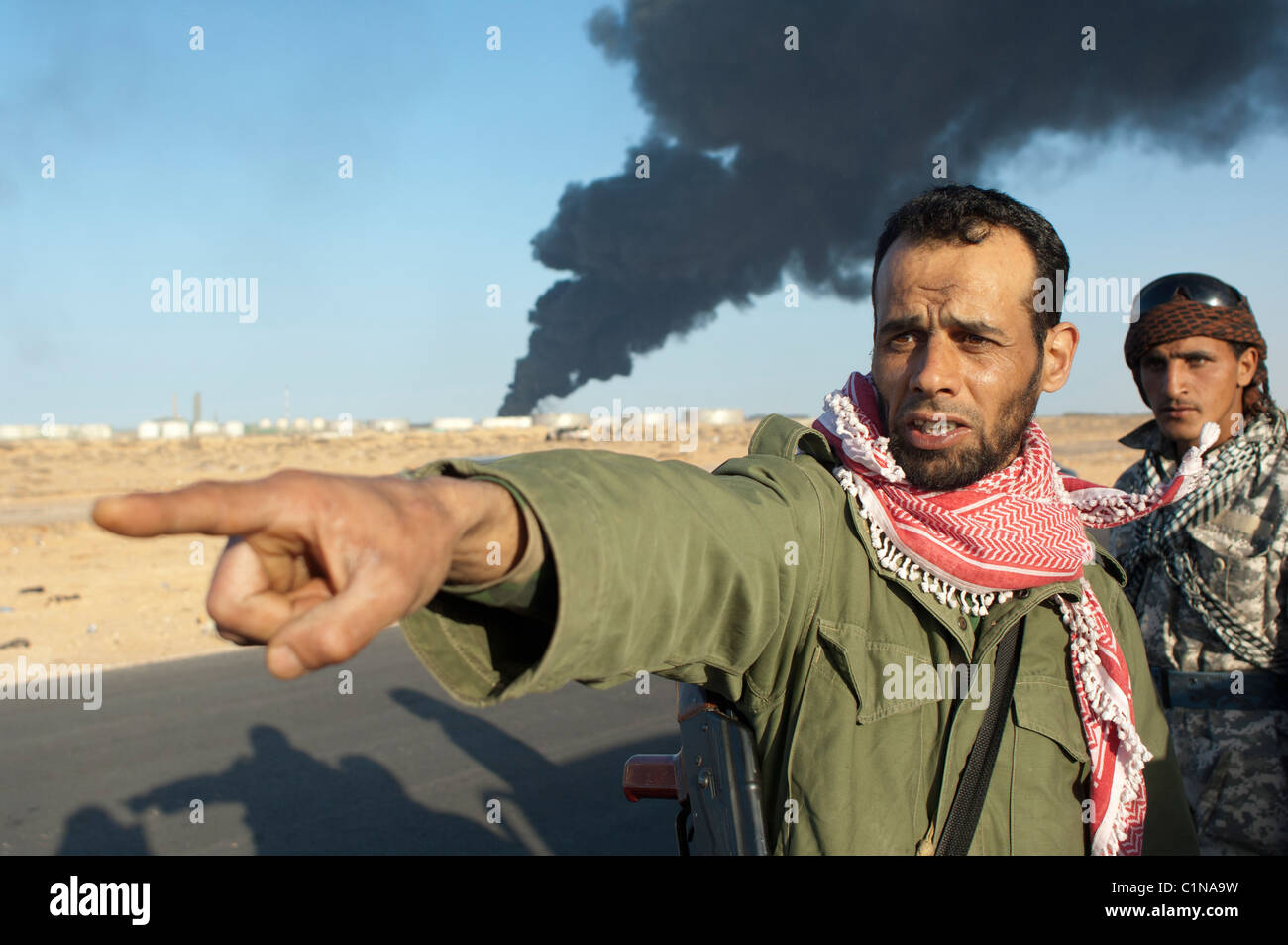 Rebel points at government tank, Ras Lanuf. Libya Stock Photo