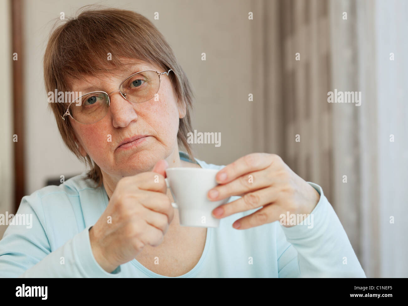 Elderly woman enjoying a cup of coffee at home Stock Photo