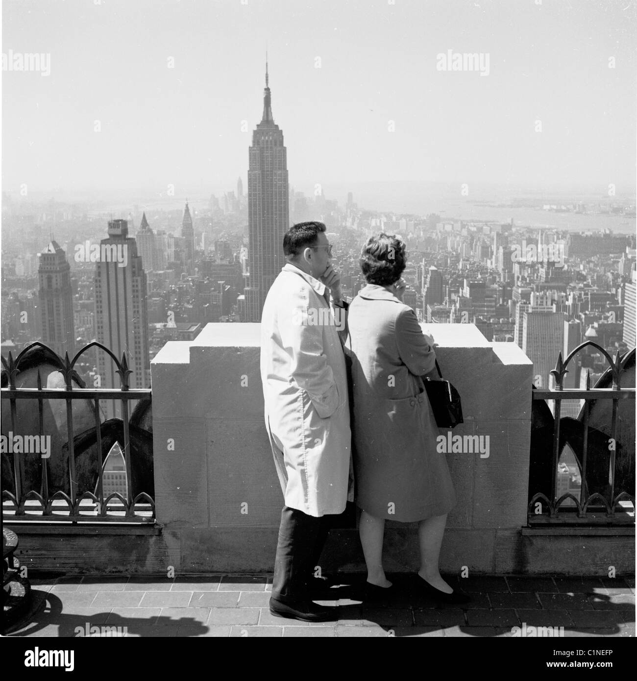 America, New York, 1950s. From the top of the Rockerfeller centre, a couple look at the view across city's skyline. Stock Photo
