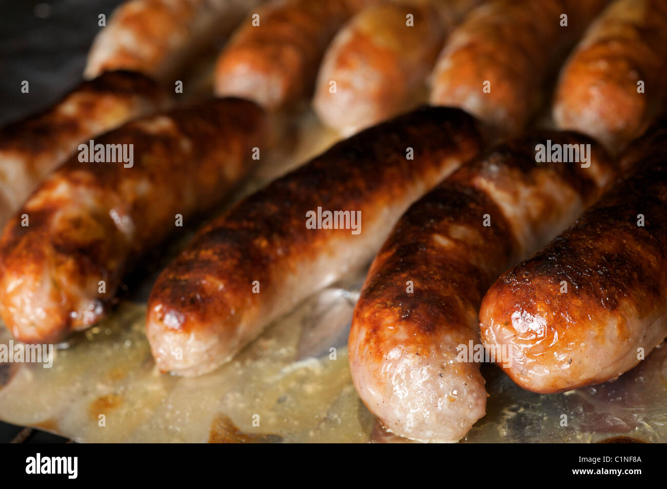 Sausages being cooked under electric grill Stock Photo