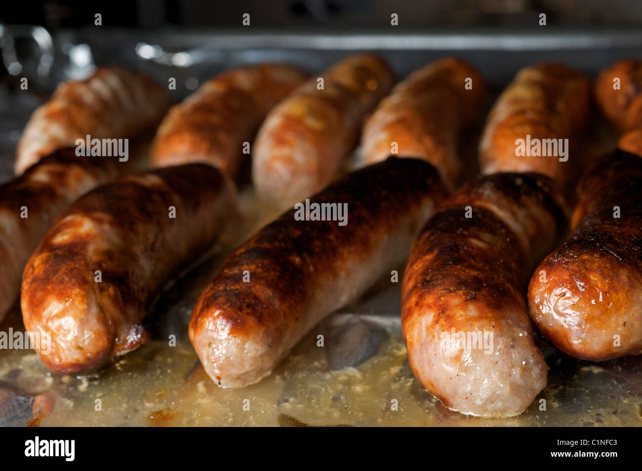 Sausages being cooked under electric grill Stock Photo Alamy