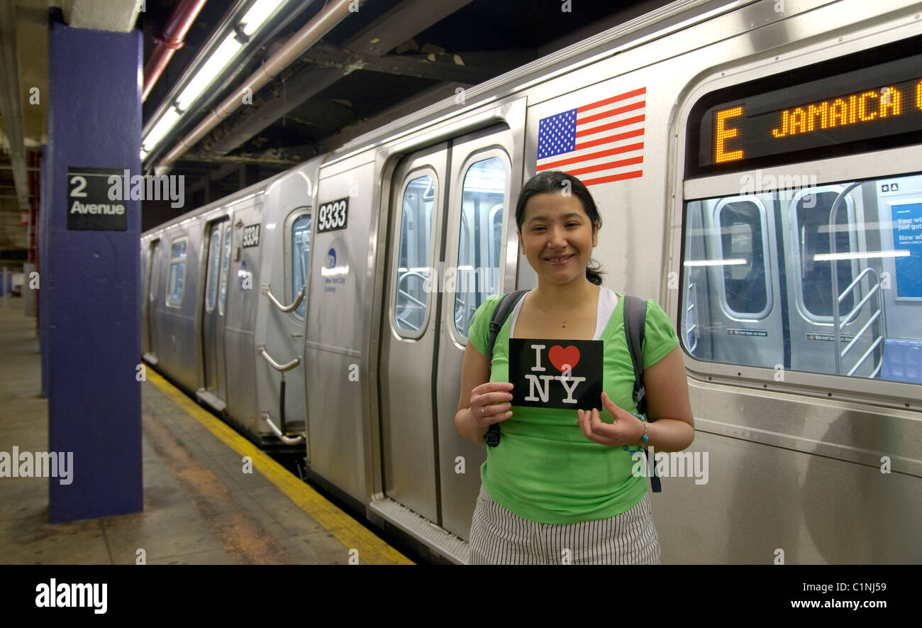 Latino woman holding “I Love New York” postcard, Subway train metro station, New York City Stock Photo