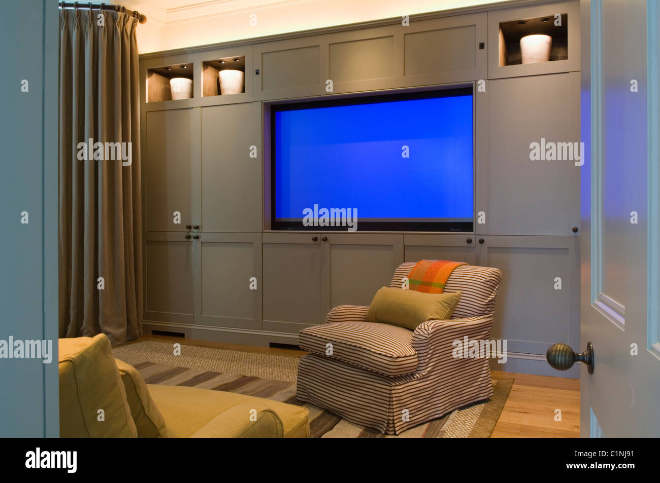 Flat screen home cinema in living room with armchair Stock Photo