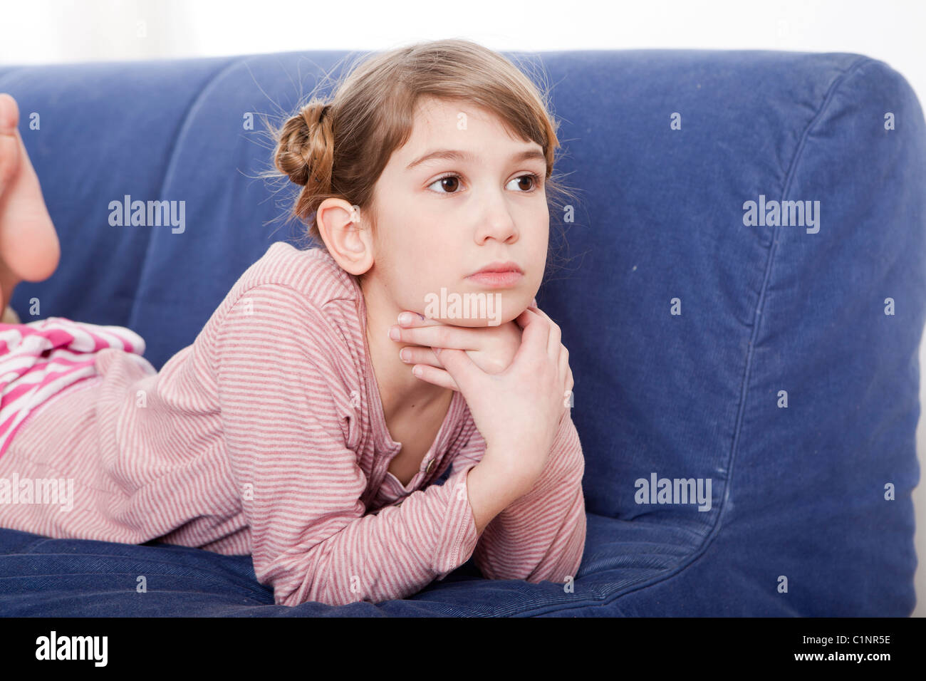 Calm little girl laying and looking ahead Stock Photo - Alamy