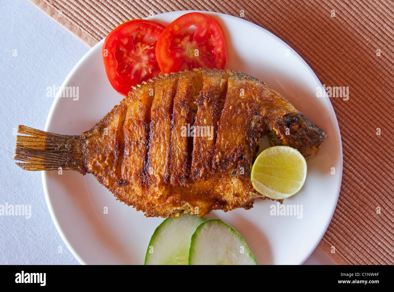 Fried fish lunch on houseboat cruise of the tropical Kerala Backwaters on the Malabar coast of South India. Stock Photo