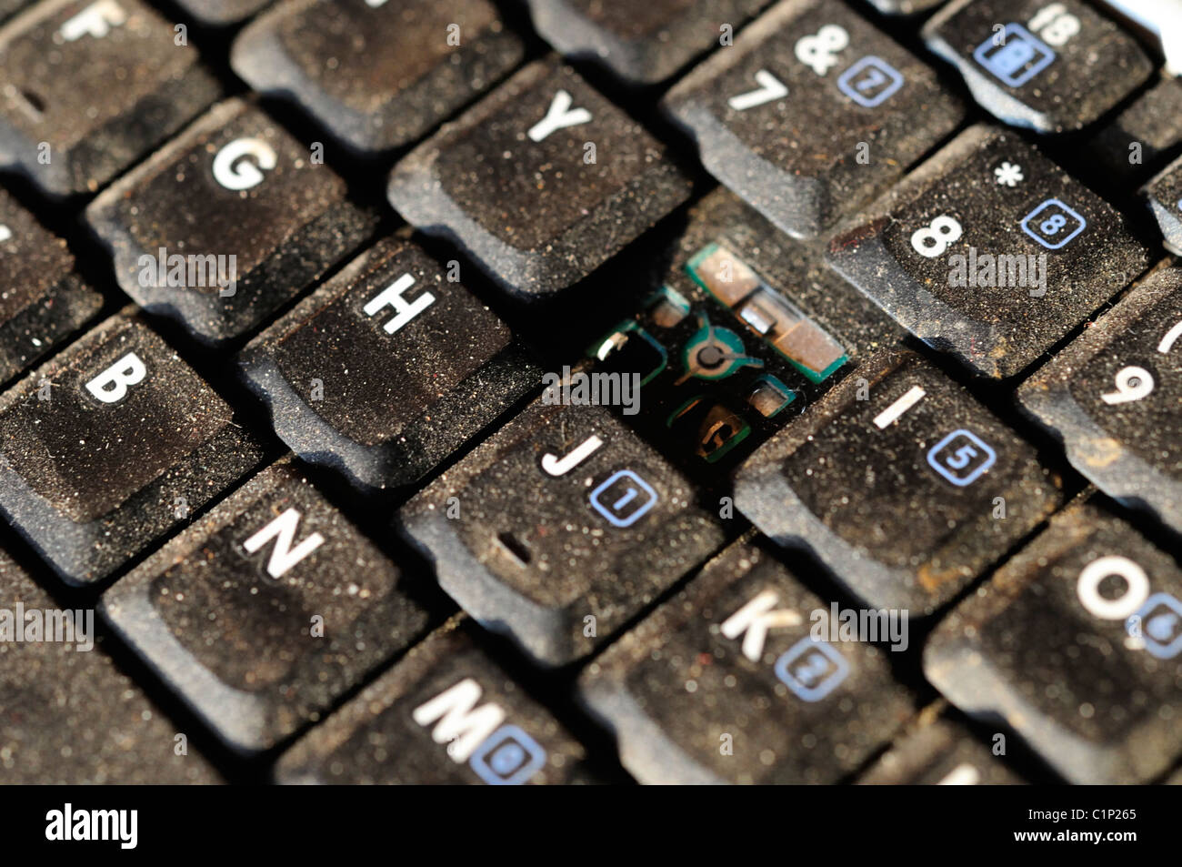 A dusty notebook keyboard with the letter 'U' missing. Stock Photo