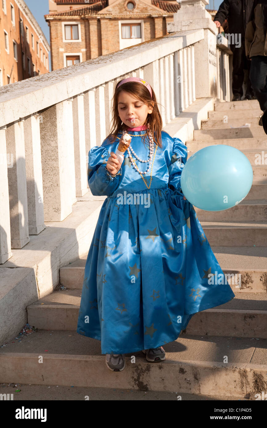 Young girl in costume enjoying an ice cream, the Venice Carnival, Venice Italy Stock Photo