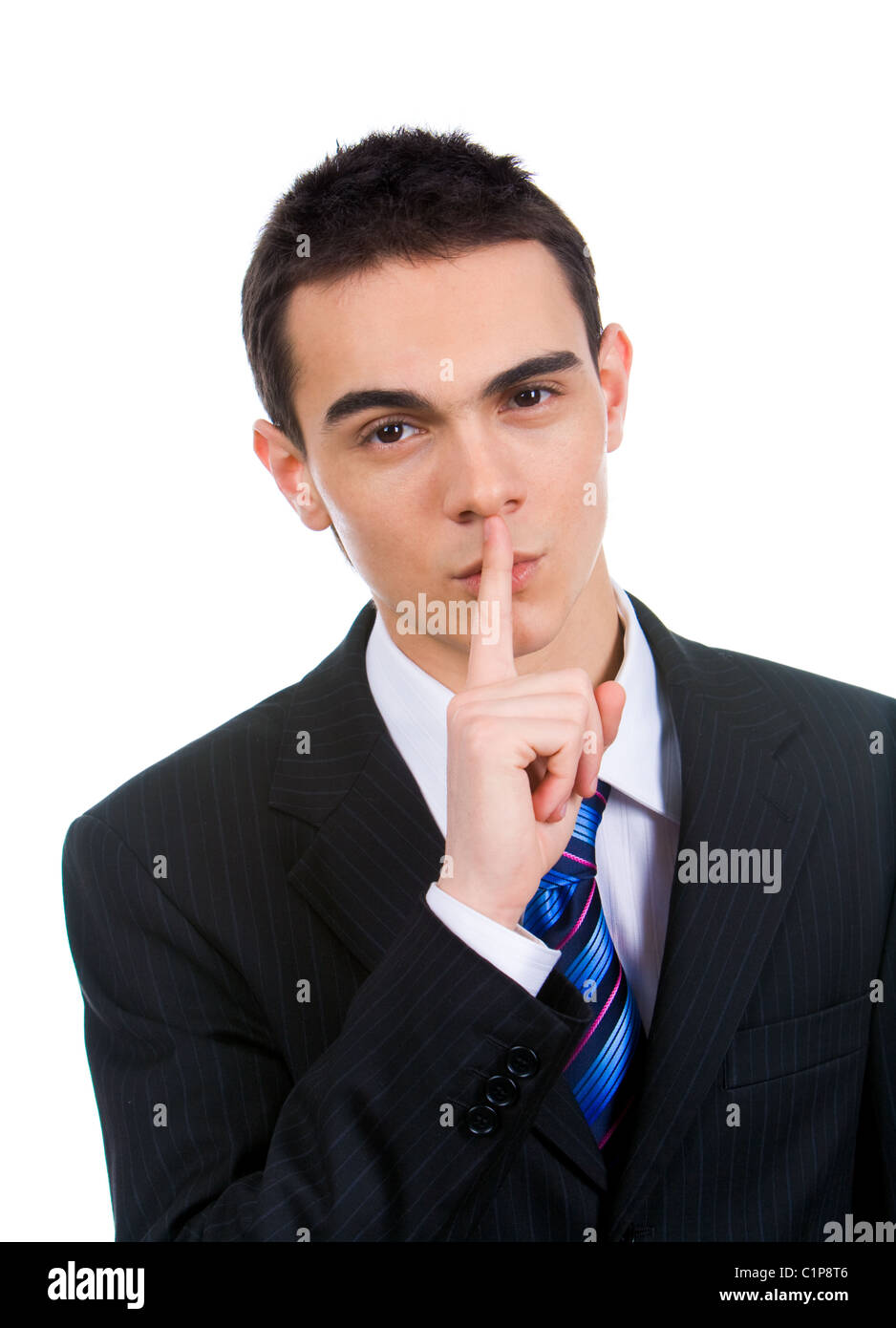 Portrait of businessman showing silence gesture with his forefinger by mouth Stock Photo