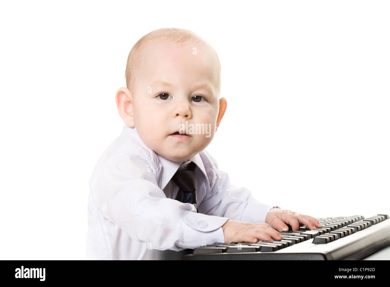 Photo of serious baby typing on keyboard and looking at camera Stock