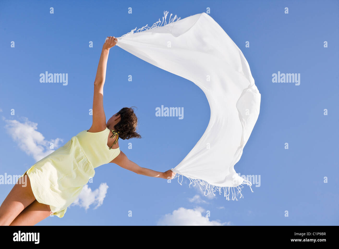 Young woman holding shawl against sky Stock Photo