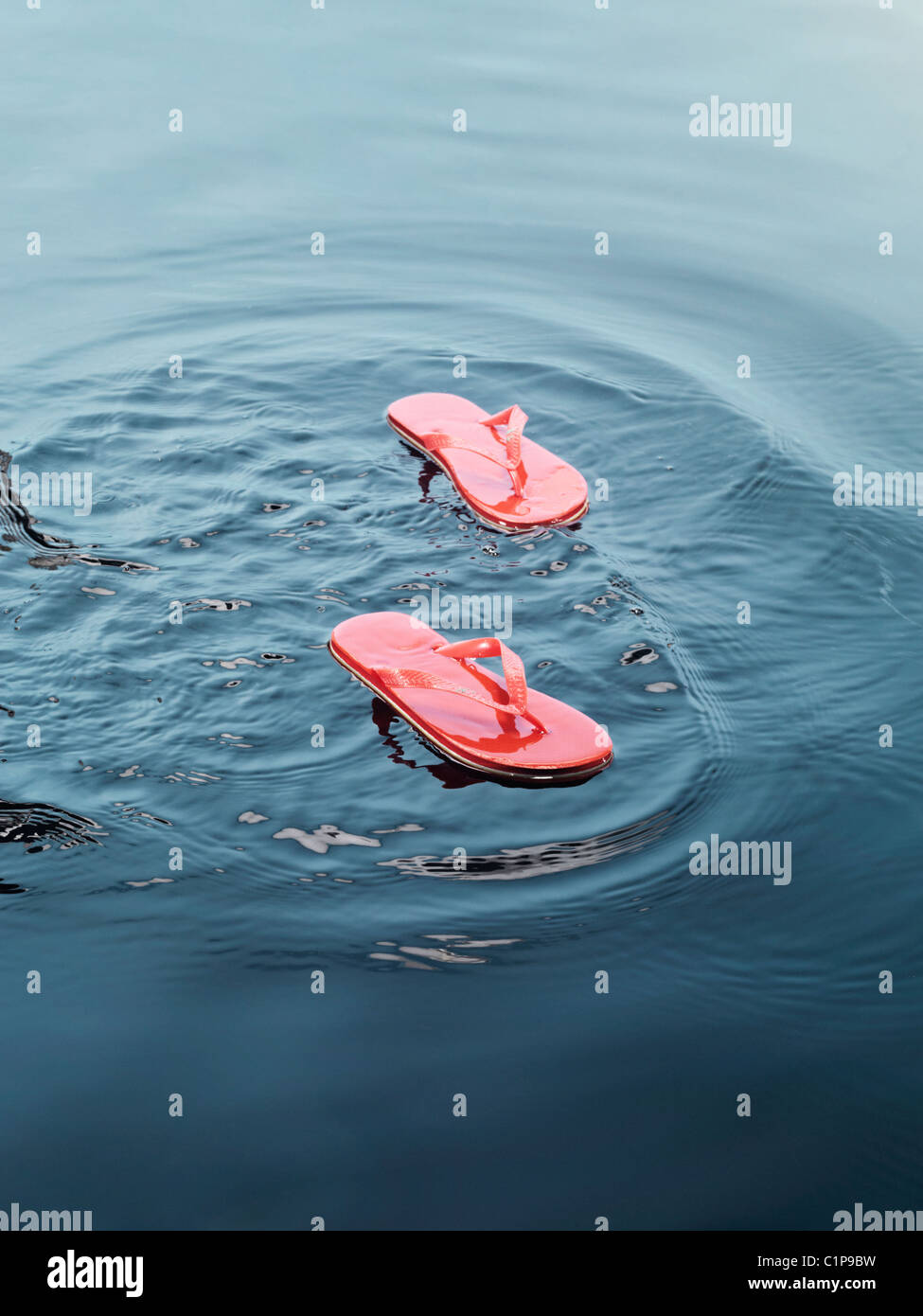 Flip flops floating on water Stock Photo