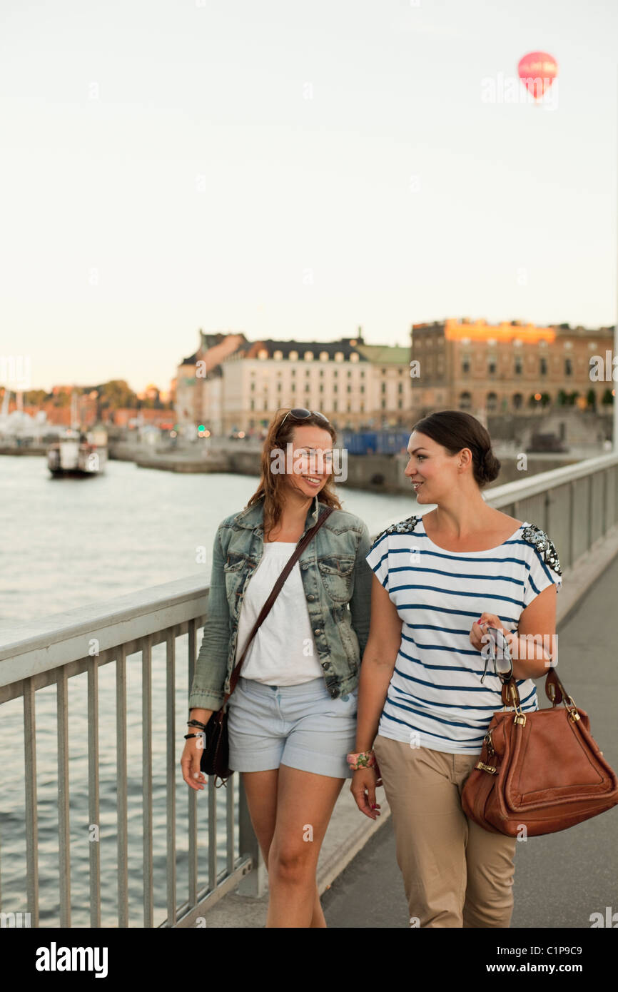 Two women walking Through bridge, laughing Stock Photo - Alamy