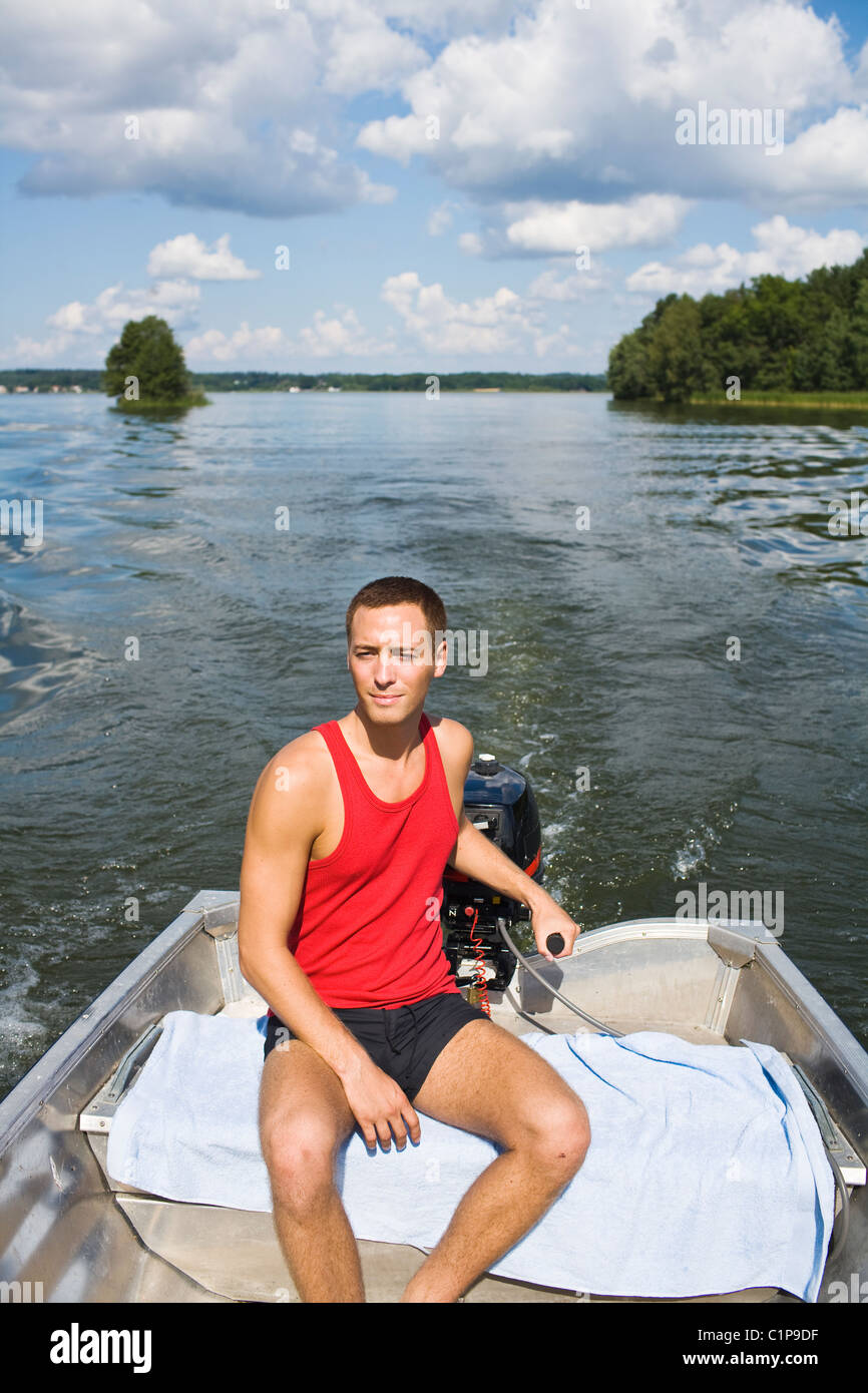 Young man on motorboat Stock Photo - Alamy