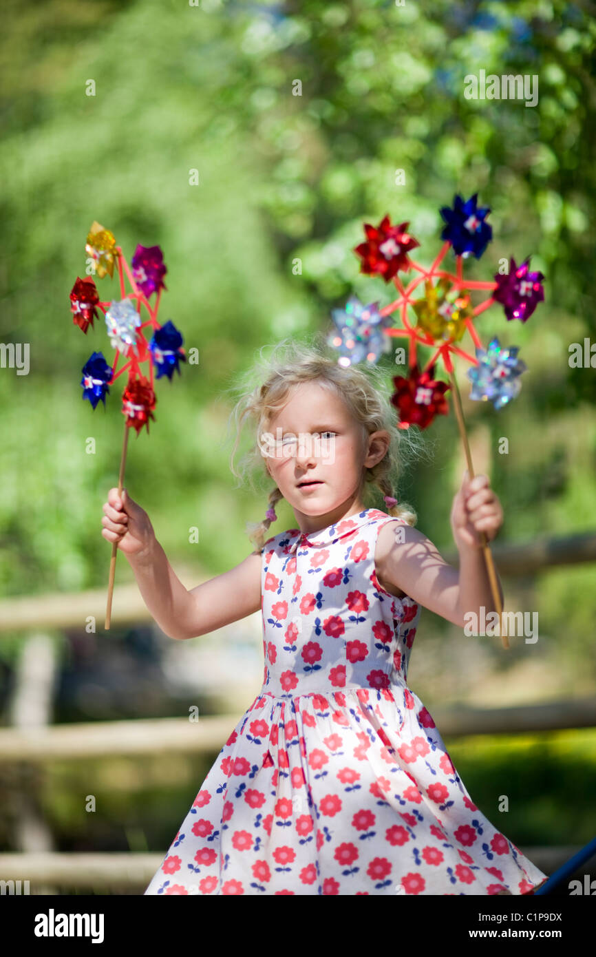 Portrait of girl holding paper windmill toys Stock Photo - Alamy