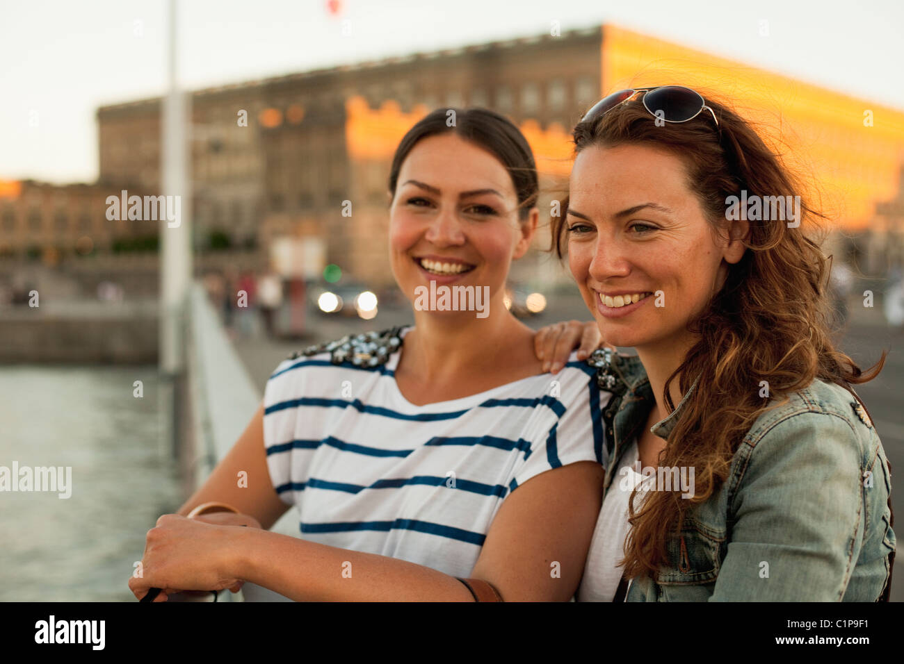 Two women standing on bridge, smiling Stock Photo - Alamy