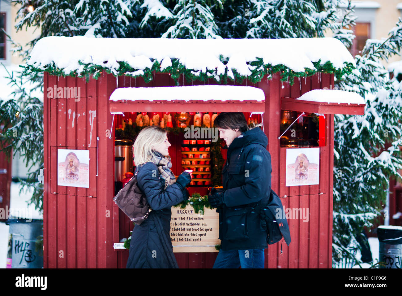 Couple standing in front of food stall in snow Stock Photo
