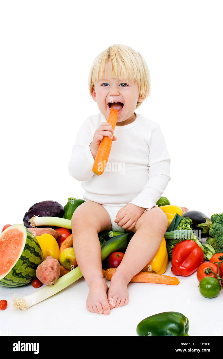 Studio shot of baby boy surrounded by fresh vegetables Stock Photo