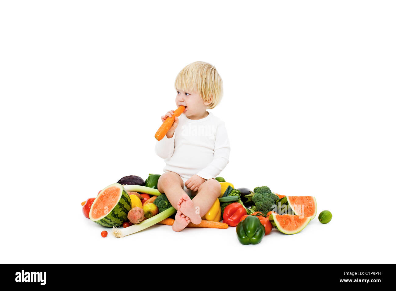 Studio shot of baby boy surrounded by fresh vegetables Stock Photo