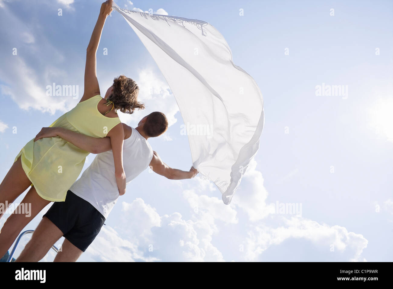 Young couple holding shawl above heads Stock Photo