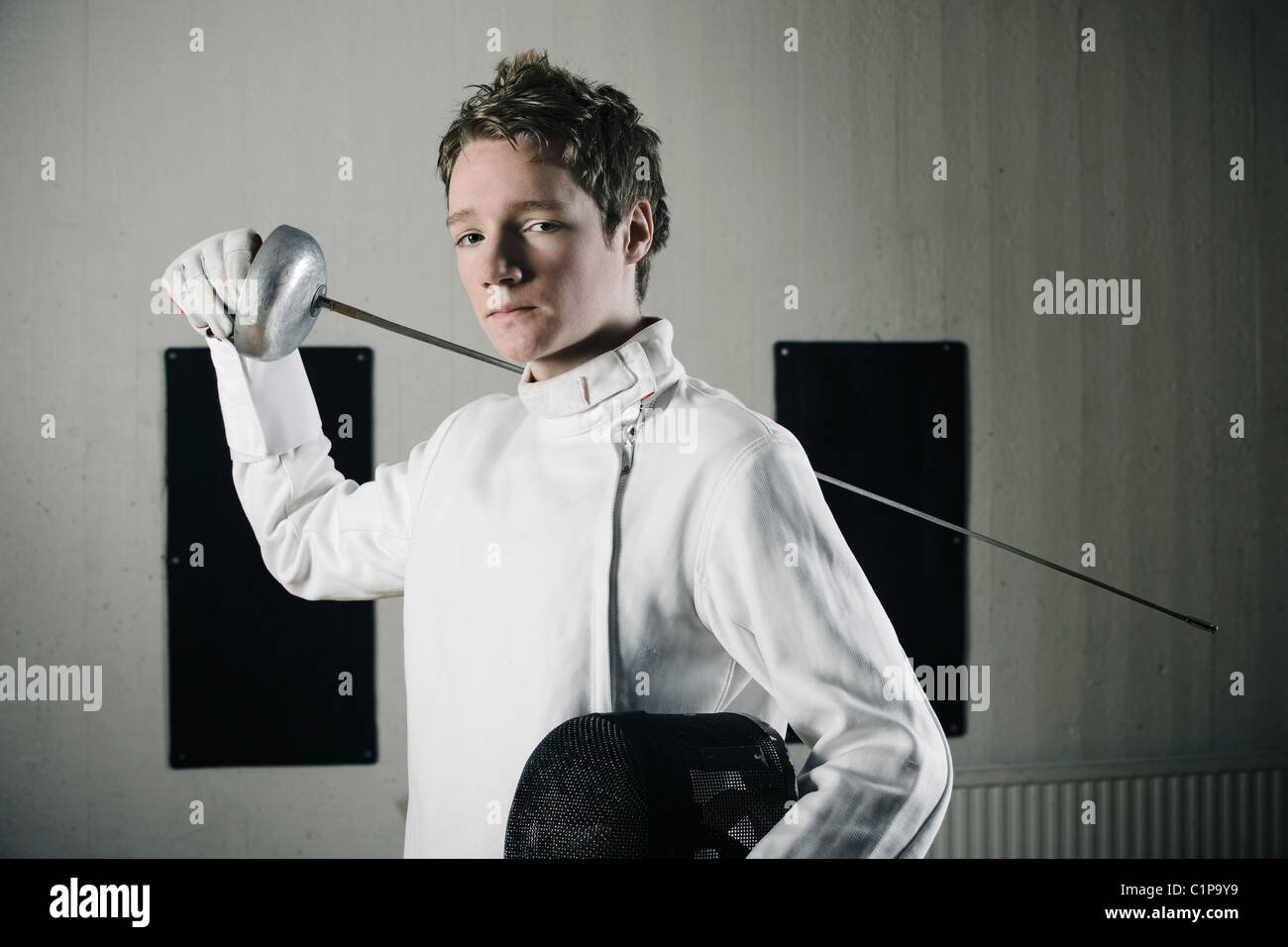 Portrait of male fencer in sports hall Stock Photo