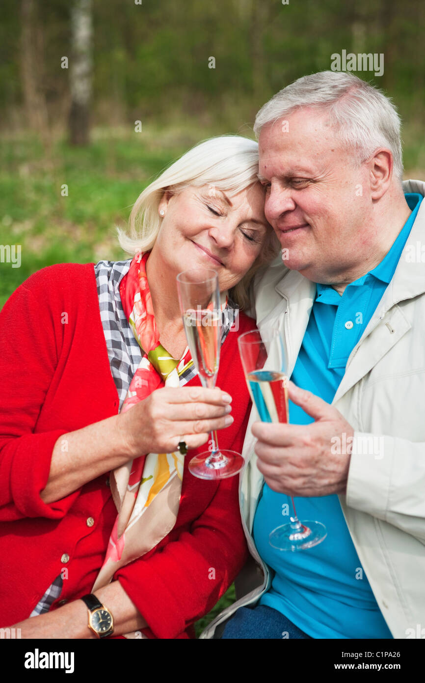 Senior couple drinking wine in park Stock Photo