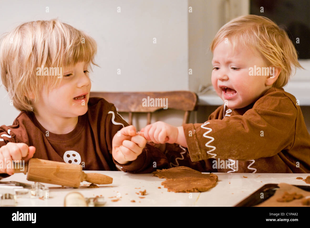 Brother and sister fighting while preparing gingerbread Stock Photo